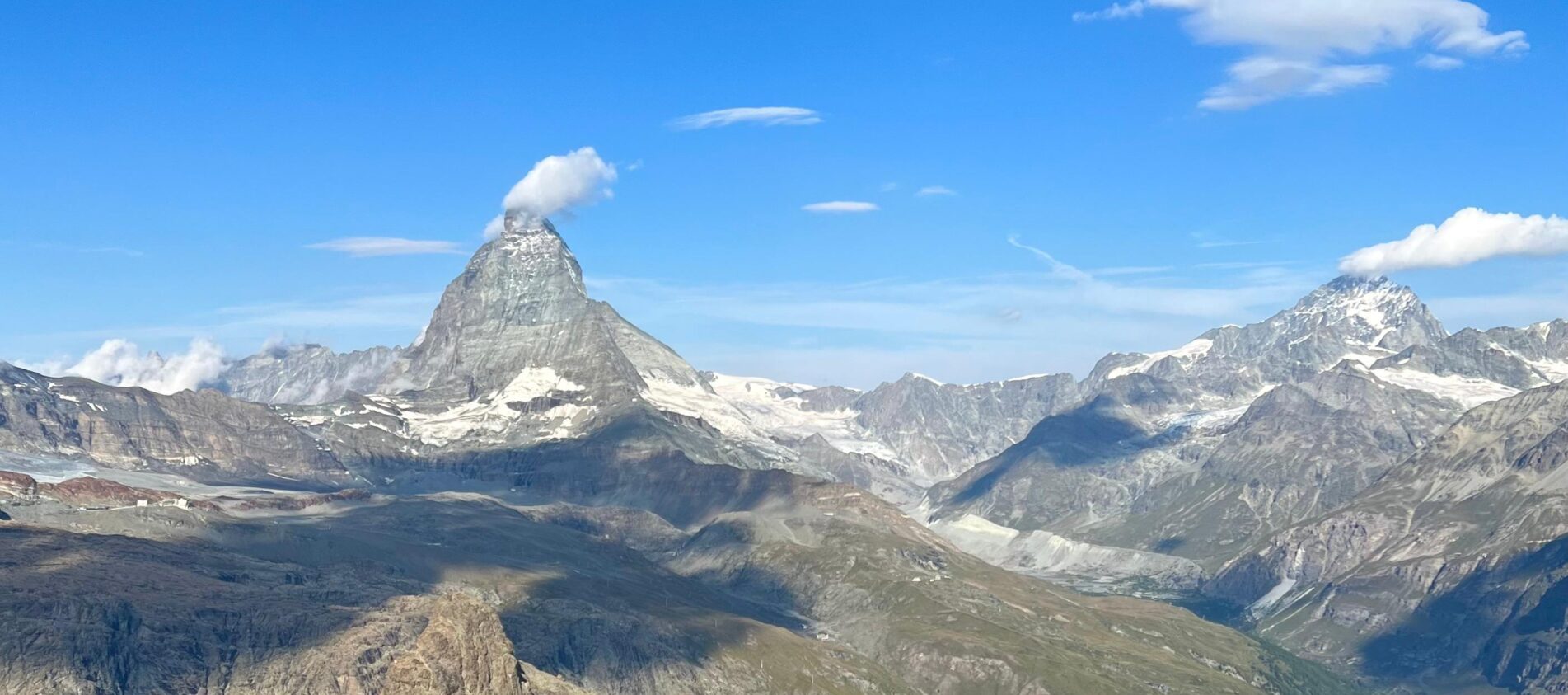 Gornergrat Railway train approaching the summit station with the Matterhorn and surrounding Alps in the background
